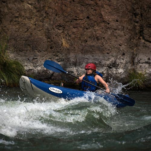 Boarding school student in a whitewater inflatable kayak 